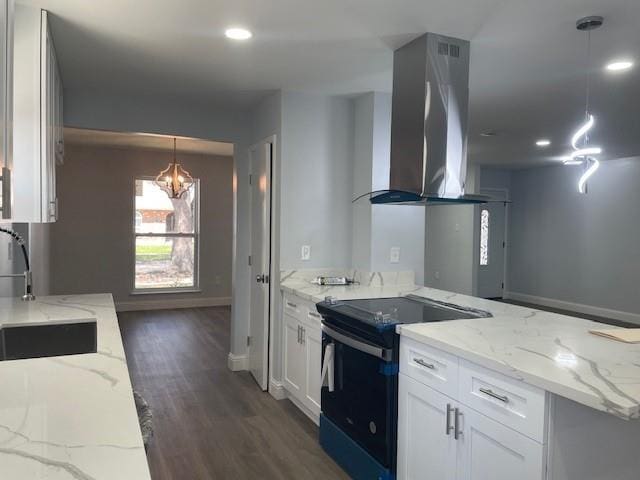 kitchen with light stone counters, island exhaust hood, electric range, white cabinets, and a sink