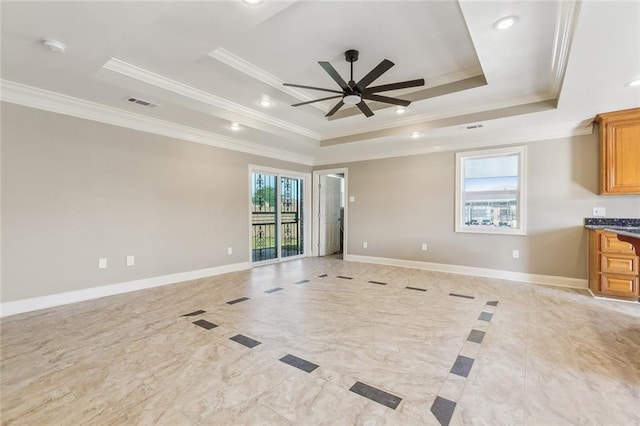 unfurnished living room featuring a tray ceiling, baseboards, visible vents, and ornamental molding