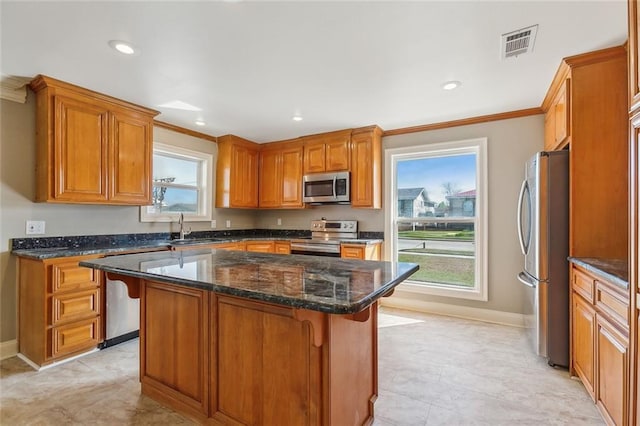 kitchen featuring a sink, visible vents, a kitchen breakfast bar, and appliances with stainless steel finishes