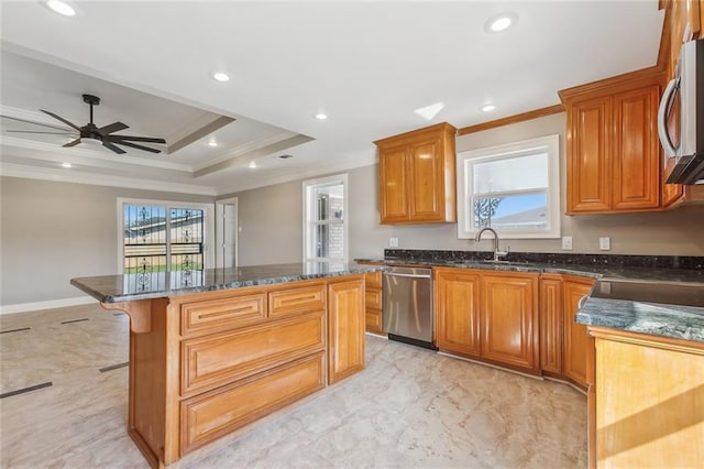 kitchen with a sink, a tray ceiling, a center island, stainless steel appliances, and crown molding