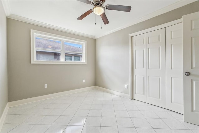 unfurnished bedroom featuring ceiling fan, a closet, baseboards, and ornamental molding