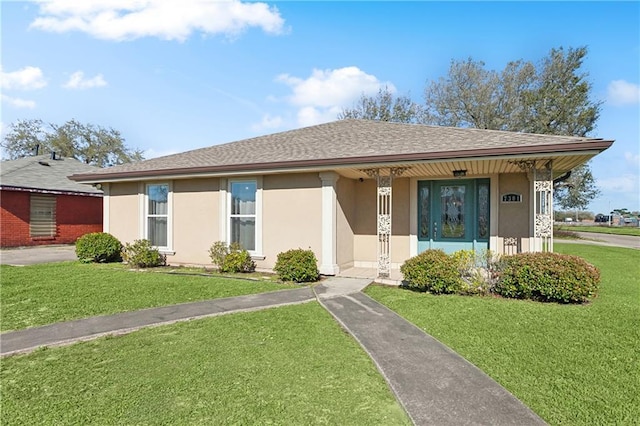 view of front of property with stucco siding, a front lawn, and roof with shingles