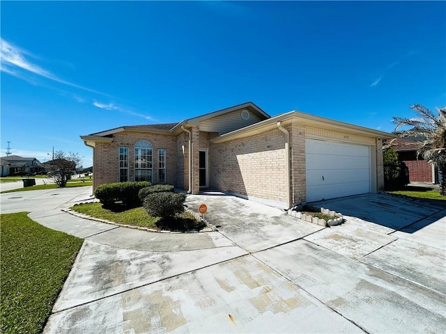 view of front of house featuring brick siding, an attached garage, and concrete driveway