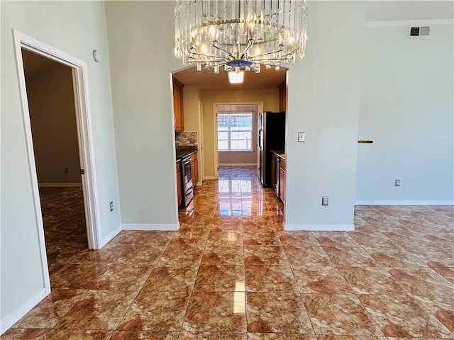 unfurnished dining area featuring visible vents, an inviting chandelier, and baseboards