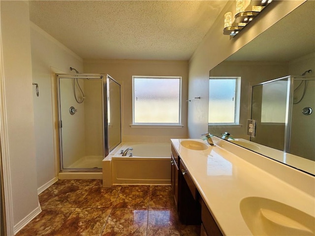 full bathroom with a textured ceiling, a shower stall, and a sink