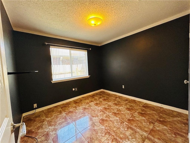 spare room featuring a textured ceiling and baseboards