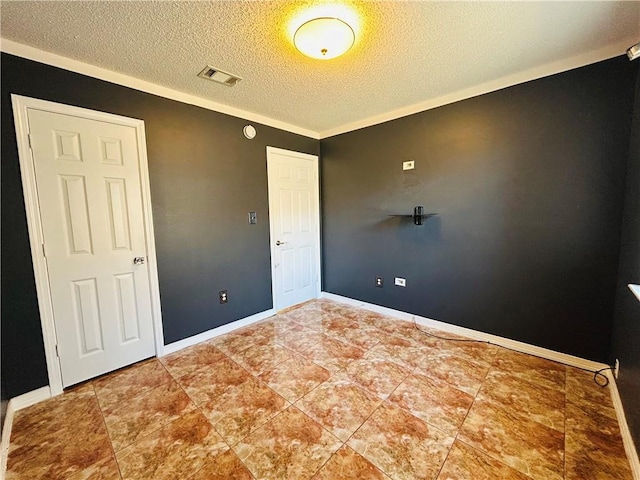 empty room featuring visible vents, baseboards, a textured ceiling, and ornamental molding