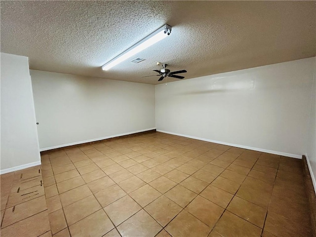 spare room featuring baseboards, visible vents, a textured ceiling, and a ceiling fan