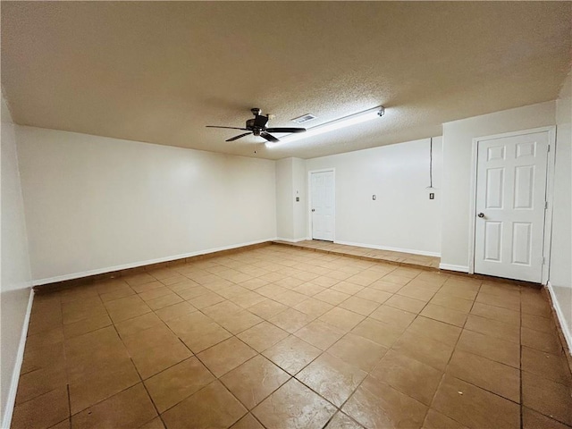 unfurnished room featuring baseboards, tile patterned floors, a textured ceiling, and ceiling fan