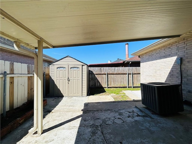 view of patio featuring a fenced backyard, a storage shed, central AC unit, and an outdoor structure