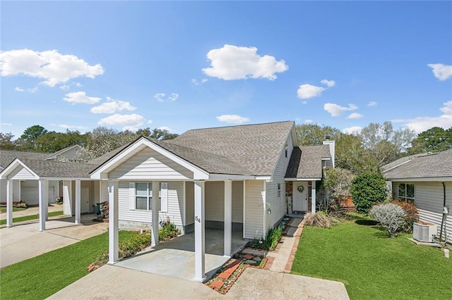 bungalow with driveway, a front lawn, roof with shingles, a carport, and a chimney