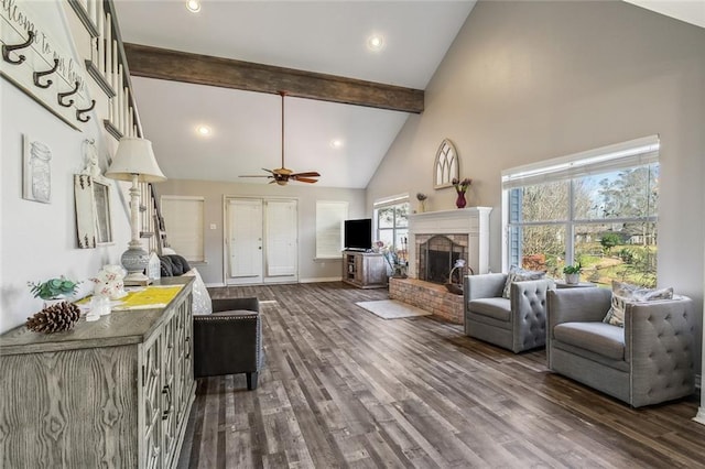 living area with beam ceiling, high vaulted ceiling, a fireplace with raised hearth, dark wood finished floors, and baseboards