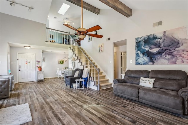 living room featuring visible vents, stairway, beam ceiling, wood finished floors, and a ceiling fan