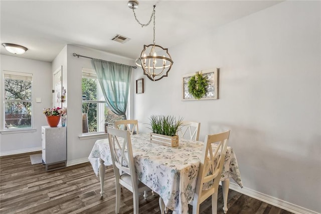 dining room with visible vents, an inviting chandelier, baseboards, and wood finished floors