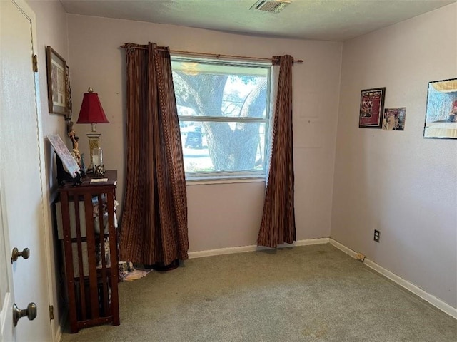 spare room featuring visible vents, baseboards, and carpet flooring