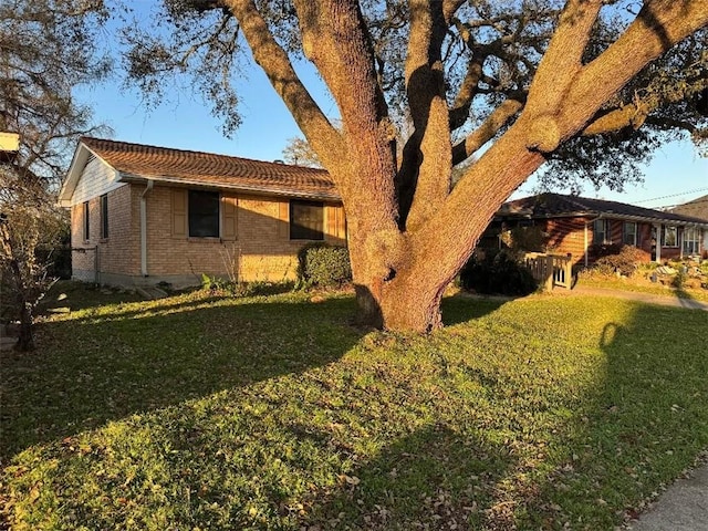 view of home's exterior featuring a lawn and brick siding