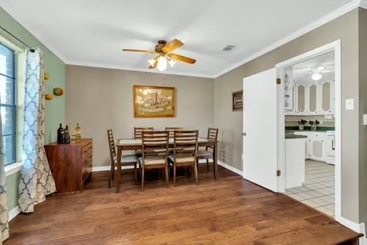 dining area with visible vents, wood finished floors, a ceiling fan, and ornamental molding