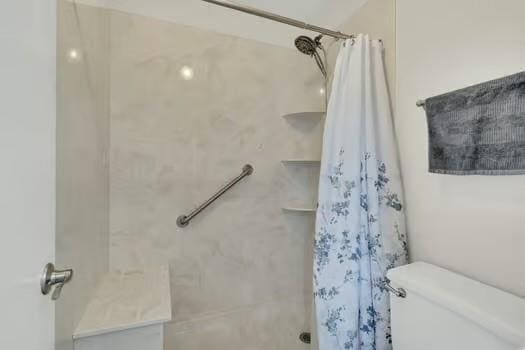 full bathroom featuring a shower with curtain and toilet