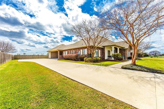 ranch-style house with concrete driveway, fence, brick siding, and a front lawn