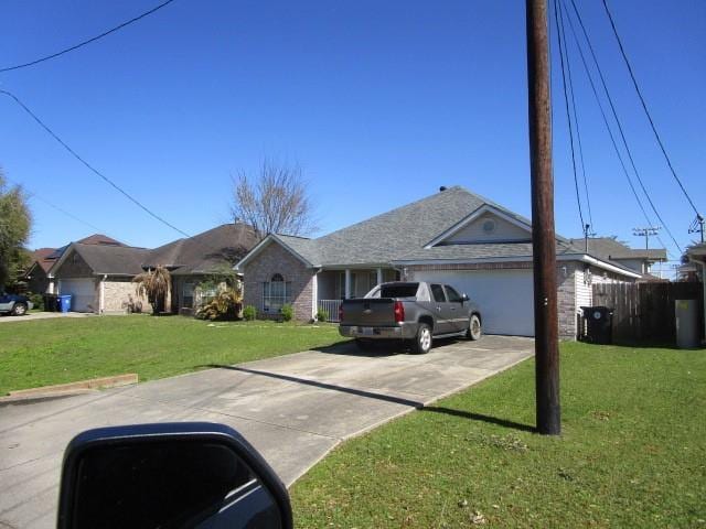 single story home featuring concrete driveway, a garage, and a front yard