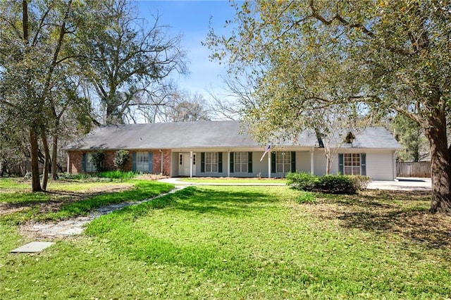 ranch-style house featuring brick siding, a front lawn, and fence