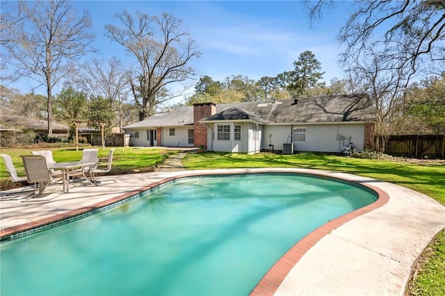 view of swimming pool featuring a fenced in pool, fence, a lawn, cooling unit, and a patio area