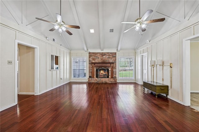 unfurnished living room with a decorative wall, a fireplace, visible vents, and ceiling fan