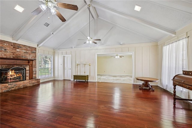 unfurnished living room featuring beamed ceiling, a fireplace, visible vents, and wood-type flooring