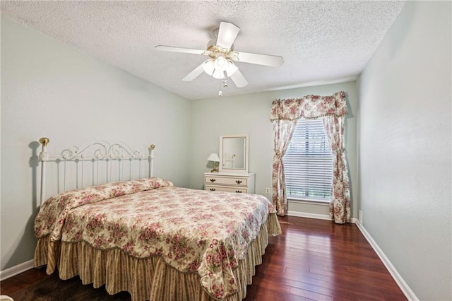 bedroom featuring dark wood finished floors, ceiling fan, baseboards, and a textured ceiling