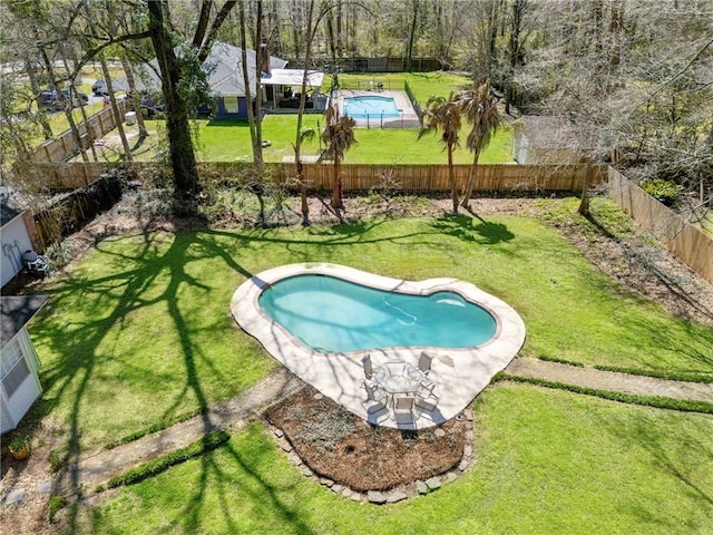 view of swimming pool featuring a fenced backyard, a fenced in pool, and a lawn