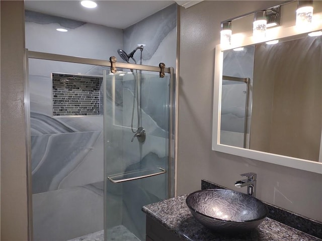 bathroom featuring a shower stall and vanity