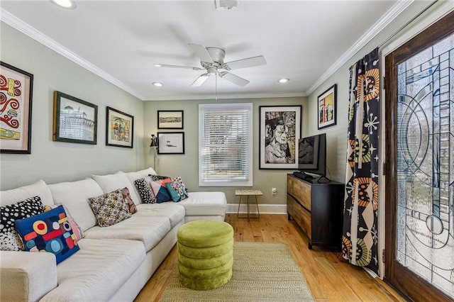 living room featuring ceiling fan, baseboards, wood finished floors, and ornamental molding