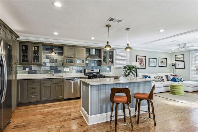 kitchen with light wood finished floors, visible vents, appliances with stainless steel finishes, and wall chimney exhaust hood