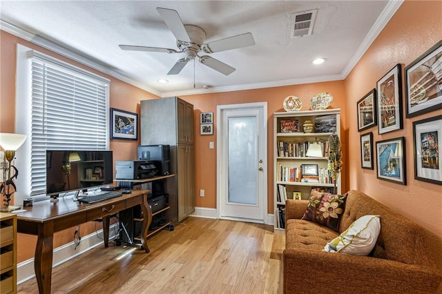 office area featuring baseboards, visible vents, ceiling fan, crown molding, and light wood-type flooring