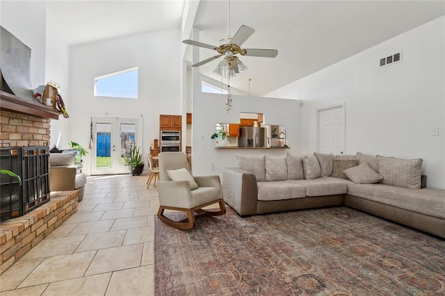 living room featuring visible vents, light tile patterned flooring, ceiling fan, french doors, and a brick fireplace