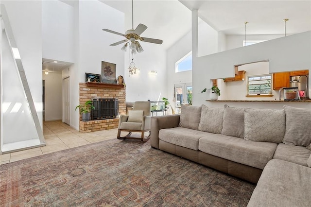 living area featuring ceiling fan, light tile patterned floors, a fireplace, and a healthy amount of sunlight