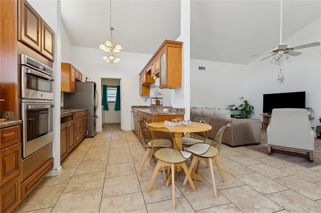 kitchen featuring light tile patterned floors, open floor plan, brown cabinets, and appliances with stainless steel finishes