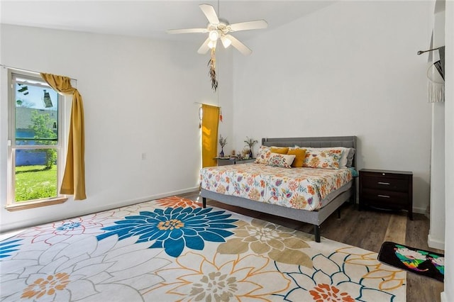 bedroom featuring baseboards, wood finished floors, and a ceiling fan