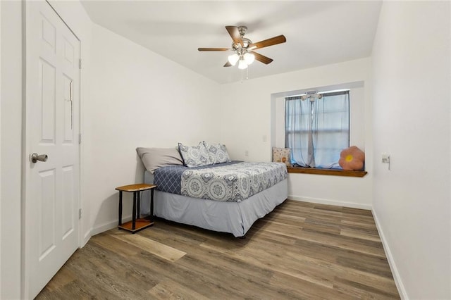 bedroom with baseboards, wood finished floors, and a ceiling fan