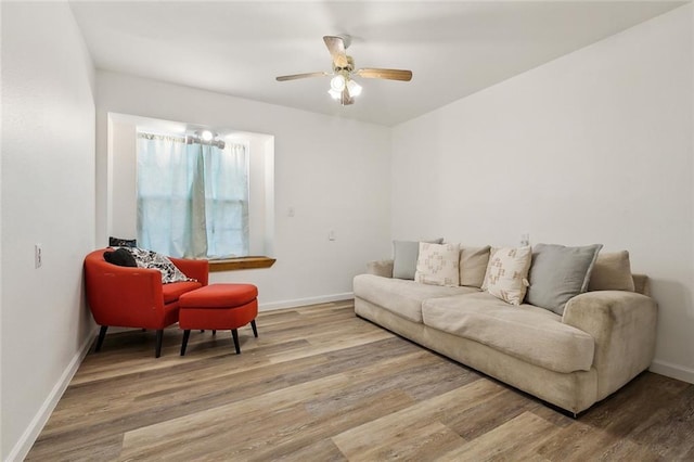 living area featuring ceiling fan, baseboards, and wood finished floors