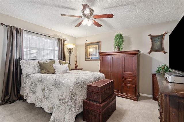 bedroom featuring a textured ceiling, ceiling fan, baseboards, and light carpet