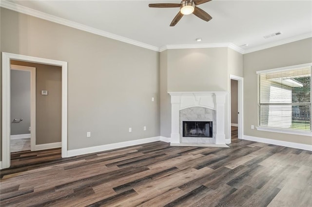 unfurnished living room with visible vents, ornamental molding, wood finished floors, a fireplace, and baseboards