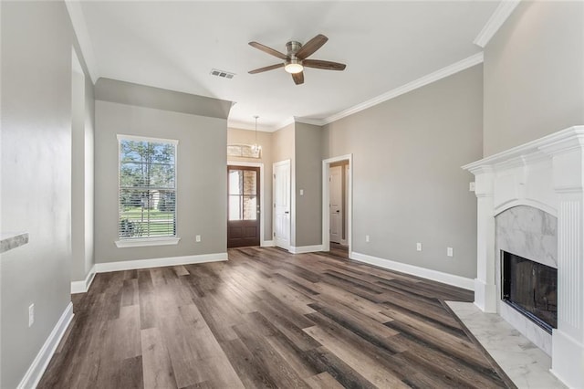 unfurnished living room featuring crown molding, baseboards, visible vents, and a premium fireplace