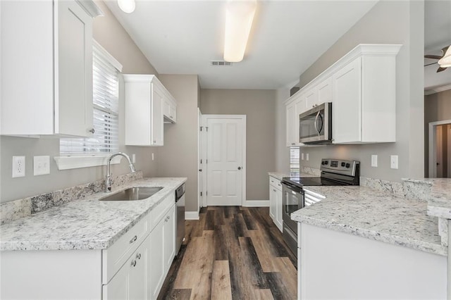 kitchen featuring a sink, stainless steel appliances, dark wood-style floors, and white cabinetry