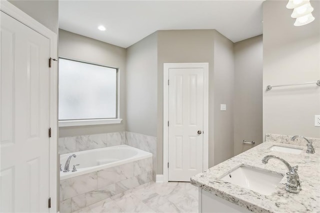 bathroom featuring double vanity, a bath, marble finish floor, and a sink