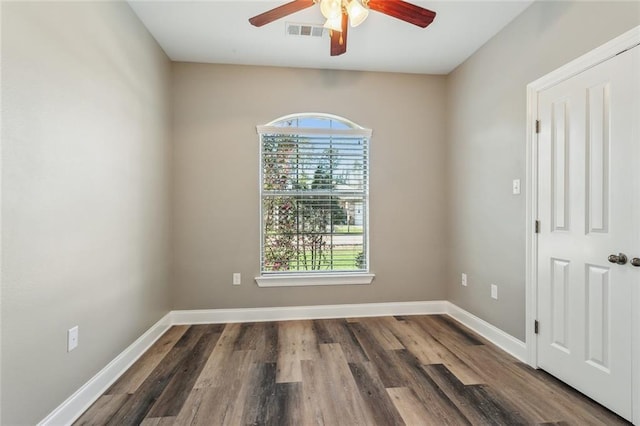 unfurnished room featuring visible vents, plenty of natural light, baseboards, and wood finished floors