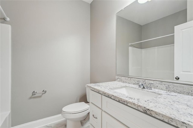 bathroom with baseboards, toilet, vanity, and walk in shower