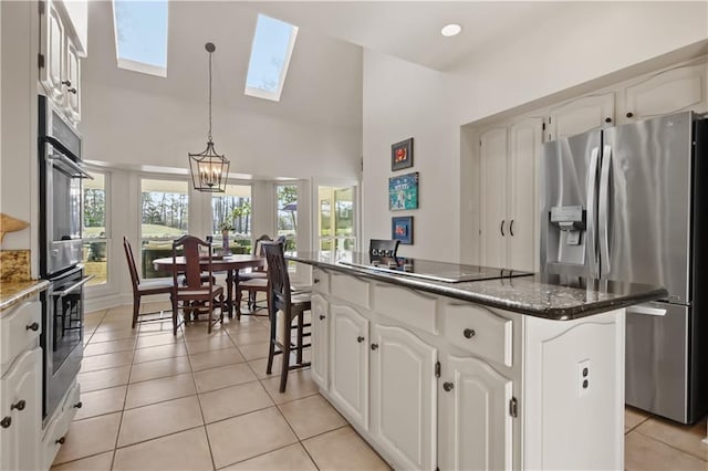 kitchen featuring light tile patterned floors, stainless steel appliances, plenty of natural light, and a center island