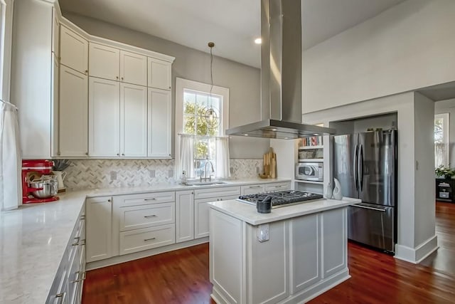 kitchen featuring island exhaust hood, a sink, backsplash, appliances with stainless steel finishes, and dark wood-style flooring