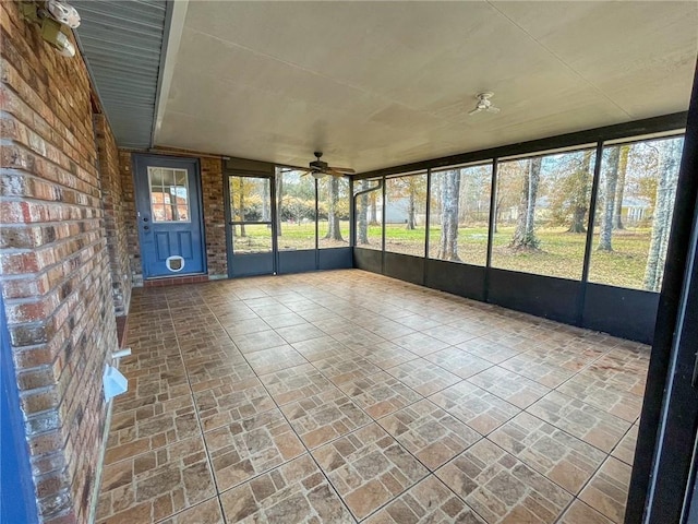 unfurnished sunroom with a ceiling fan